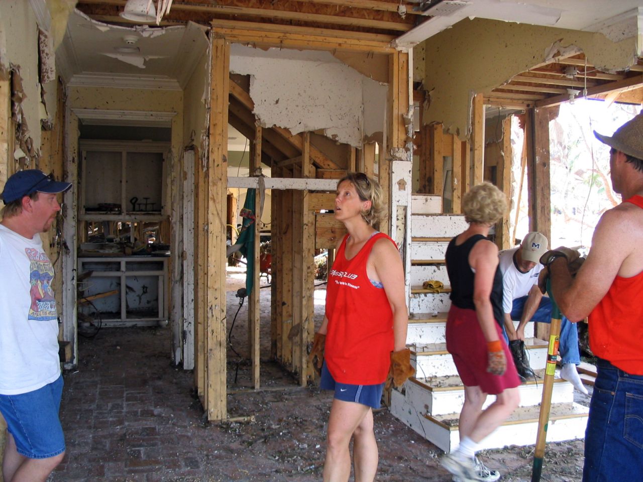 A group of neighbors surveys the damage in one home. 