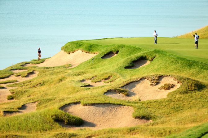 Rich Beem of the United States watches a putt on the third green.