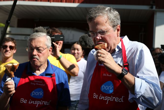 Bush and Branstad eat a pork chop on a stick on August 14.