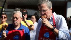 Republican presidential hopeful and former Florida Gov. Jeb Bush (R) and Iowa Gov. Terry Branstad eat a pork chop on a stick at the Iowa Pork Tent during the Iowa State Fair on August 14, 2015 in Des Moines, Iowa.
