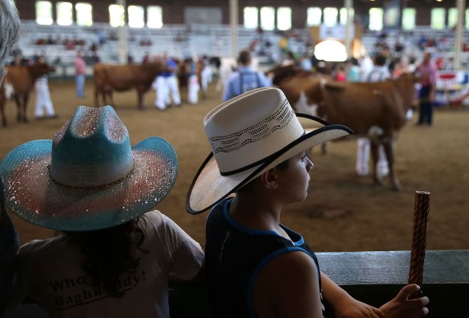Youngsters in cowboy hats watch a cattle competition on August 14.