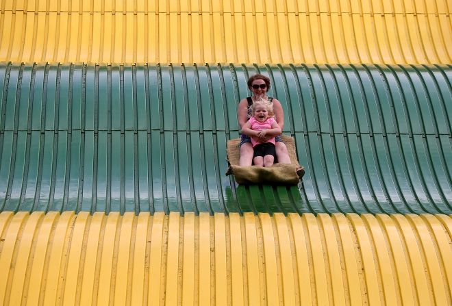 Fairgoers ride a giant slide on Thursday, August 13.