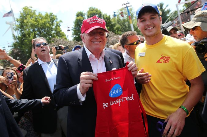 Trump holds up a personalized apron on August 15.