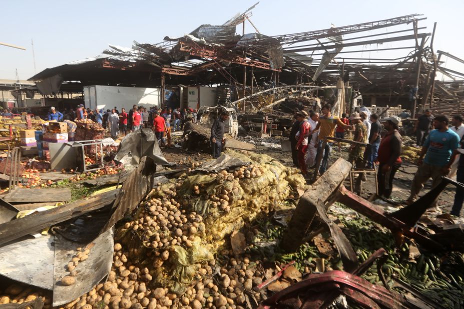 Iraqi men look at damage following a bomb explosion that targeted a vegetable market in Baghdad on Thursday, August 13. ISIS claimed responsibility for the attack.