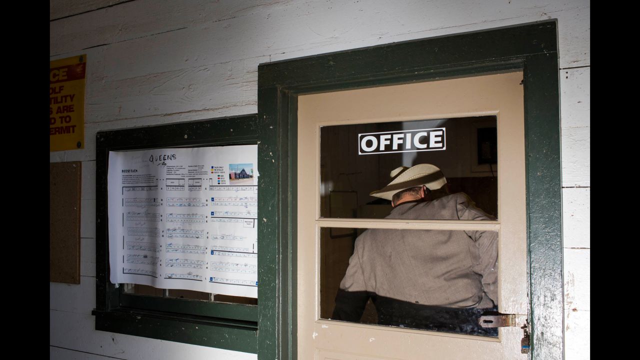 A man in a cowboy hat stands inside the office of the Horse Barn.
