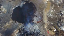 Smoke rises from debris near a crater that was at the center of a series of explosions in northeastern China's Tianjin municipality Saturday, August 15, 2015, as seen from an aerial view.