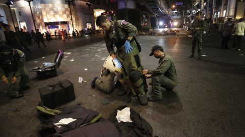 A bomb disposal team member suits up in the middle of an intersection after the blast.