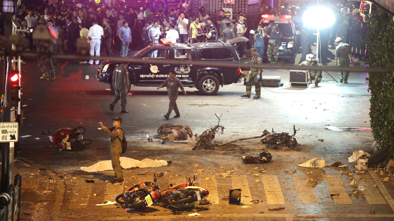 Police take photos at the scene of the explosion August 17. A bomb exploded in front of the shrine shortly after 7 p.m., a news report said.