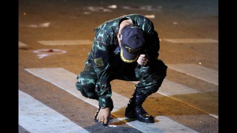 A Thai Army officer collects evidence in the street.