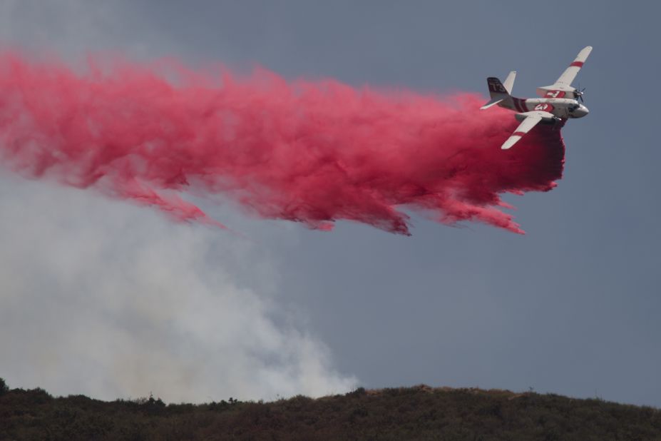 A plane drops fire retardant on the Cabin Fire north of Asuza, California, on Saturday, August 15.
