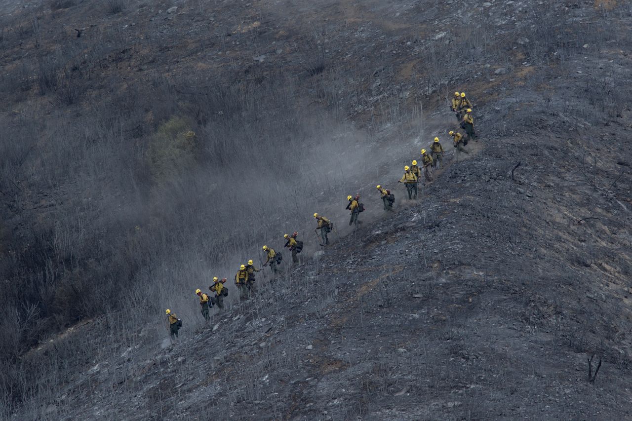 A crew descends a scorched mountainside in the Angeles National Forest on August 15.