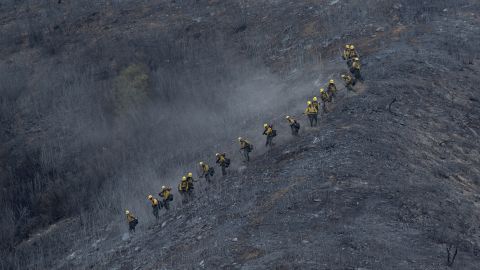 A crew descends a scorched mountainside in the Angeles National Forest on August 15.