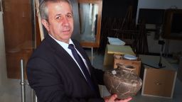 Maamoun Abdulkarim, Syria's Director-General of Antiquities and Museums, holds an ancient vase retrieved from the northeast city of Deir Ezzor.