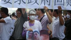 A resident injured by the explosions that hit a nearby chemical warehouse last week holds a photo of herself injured as she joins a protest outside the hotel where authorities are holding a press conferences in Tianjin on August 17, 2015. Rescuers at a Chinese industrial site where huge explosions killed at least 114 people combed through thousands of crushed shipping containers on August 17 in an effort to contain vast amounts of highly toxic cyanide, officials said, as state-run media lambasted authorities for their response to the tragedy. CHINA OUT AFP PHOTOSTR/AFP/Getty Images