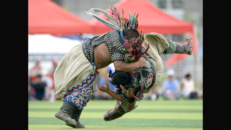 Two men compete in Mongolian wrestling Sunday, August 16, during the National Traditional Games of Ethnic Minorities of China.
