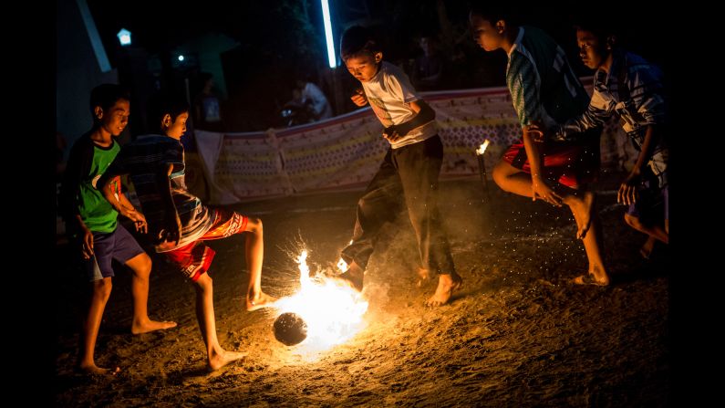 Children in Yogyakarta, Indonesia, play a game of fire soccer known as "bola api" on Saturday, August 15. The game is played with a coconut that is soaked in kerosene and set on fire.