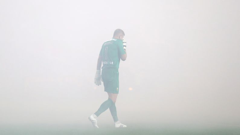 Estoril goalkeeper Pawel Kieszek is engulfed in smoke during a league match in Lisbon, Portugal, on Sunday, August 16. The smoke came from fireworks lit by supporters of the Lisbon club Benfica.
