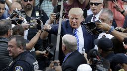 Donald Trump, center, gives a fist bump to a pedestrian as he arrives for jury duty in New York, Monday, Aug. 17, 2015. Trump was due to report for jury duty Monday in Manhattan. The front-runner said last week before a rally in New Hampshire that he would willingly take a break from the campaign trail to answer the summons. (AP Photo/Seth Wenig)