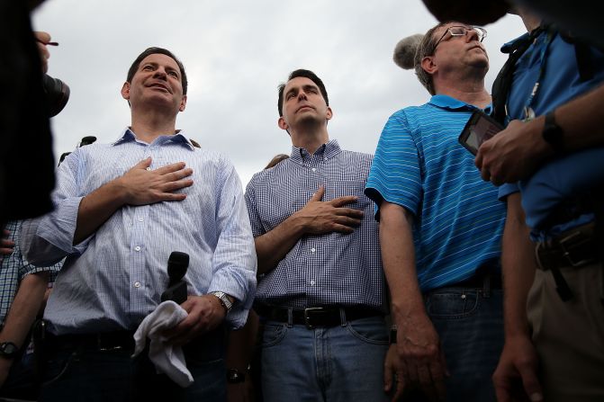 Walker, center, puts his hand over his heart as he watches a veterans parade on August 17.