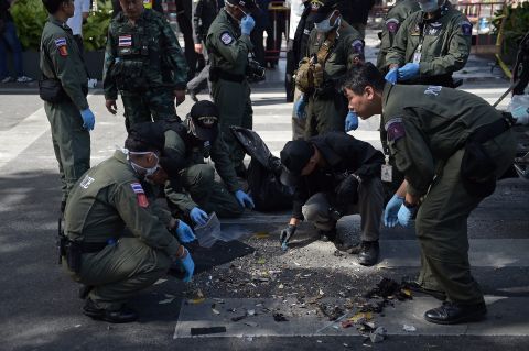 Policemen inspect the cordoned-off site of a bomb blast in the heart of Bangkok's tourist and commercial center on Monday, August 17. 