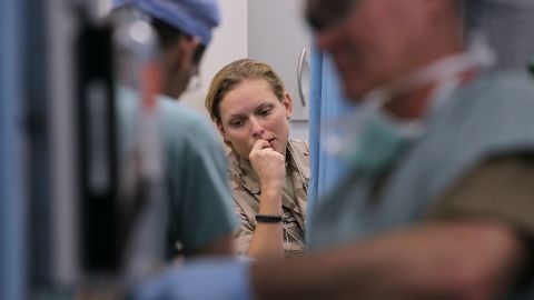 Dutch Army Korporaal Anita Van Grestiejn of the Netherlands watches a trauma team work on a soldier in Afghanistan.
