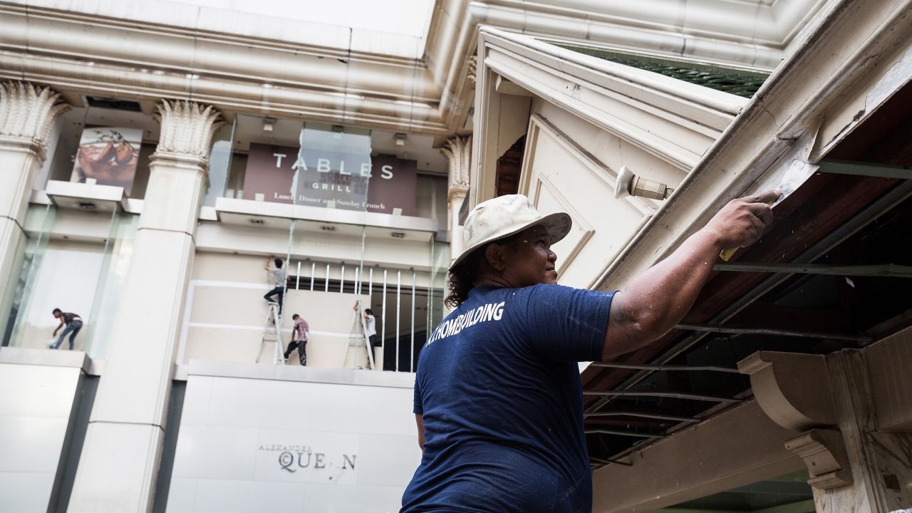 Workers make repairs to the buildings in and around the Erawan Shrine on August 19.
