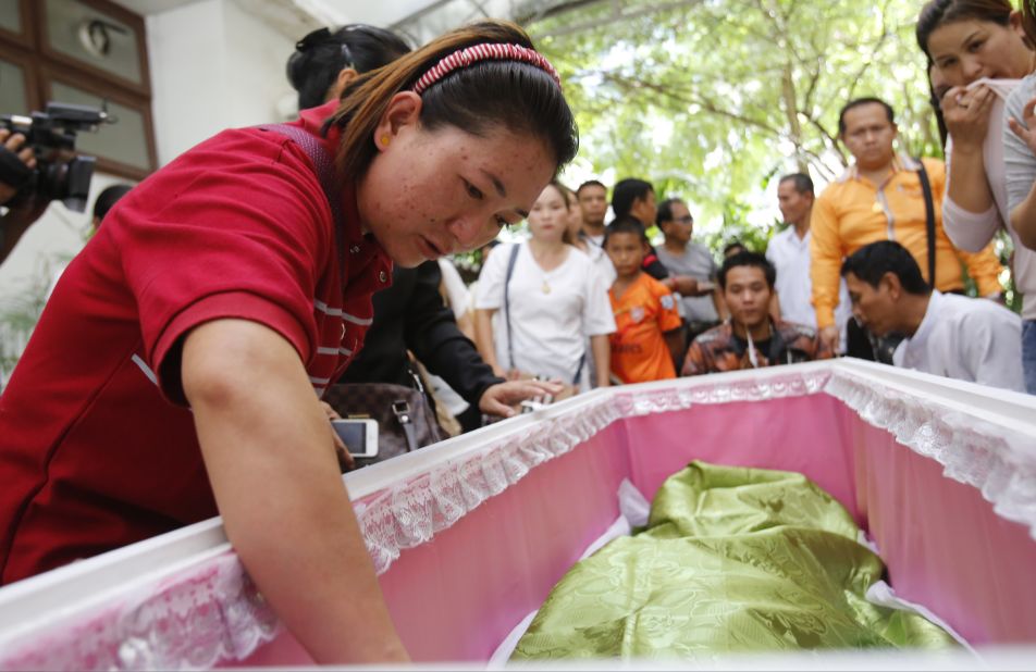 Family members gather around the coffin of a bombing victim on Tuesday, August 18. The death toll from the bomb blast in the Thai capital stood at 20 with more than 120 wounded, police said. 