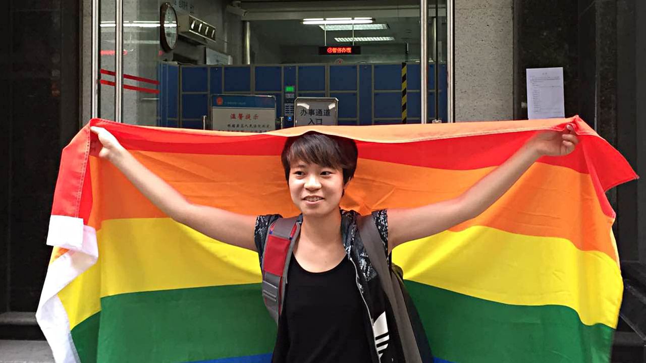 Chinese student Chen Qiuyan holds a rainbow flag, protesting in front of an intermediate court in southern China city Guangzhou on July 29, 2015. 