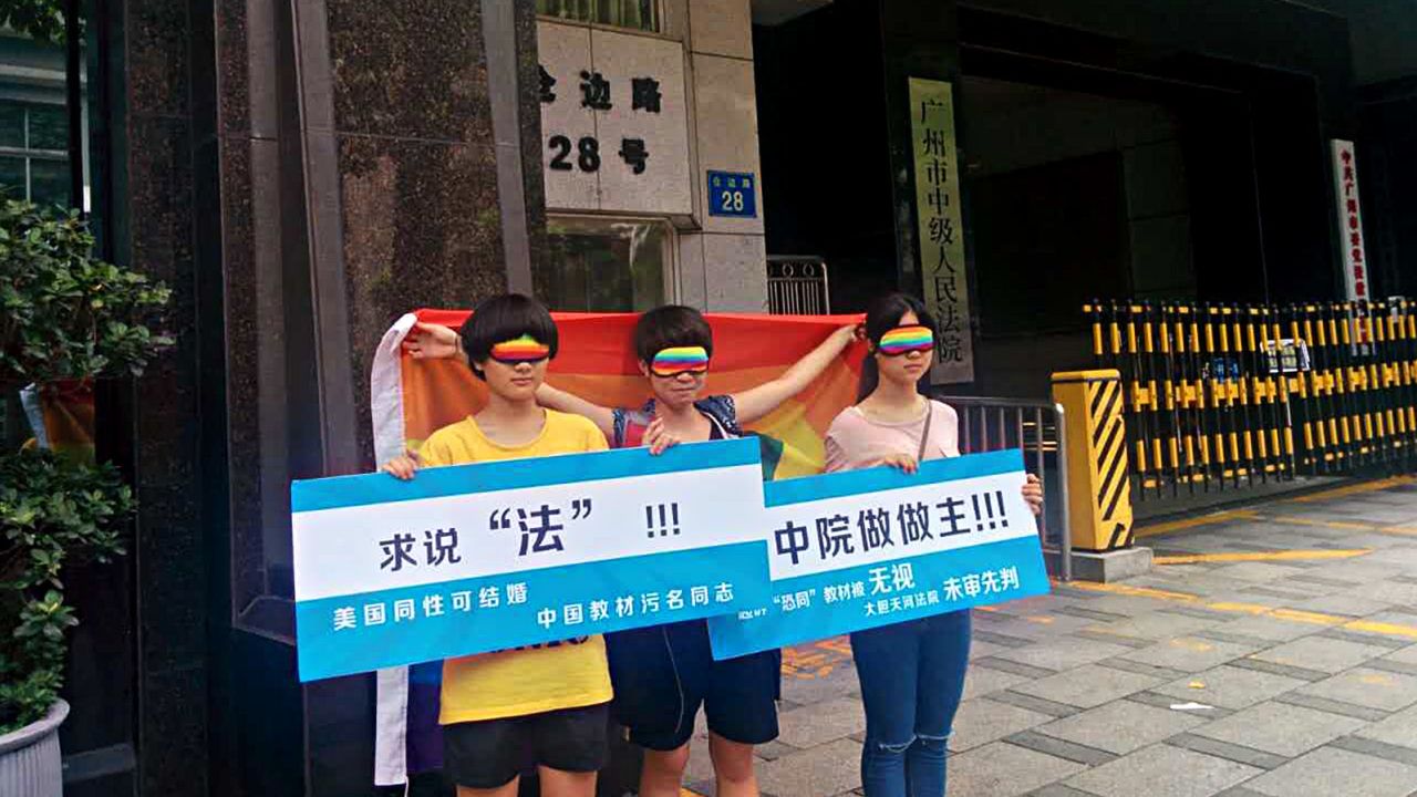 Chen Qiuyan and her friends outside a court in Guangzhou on July 29, 2015. The board on the left reads: "Seeking justice. Gay people can get married in the United States, but text books stigmatize them in China."