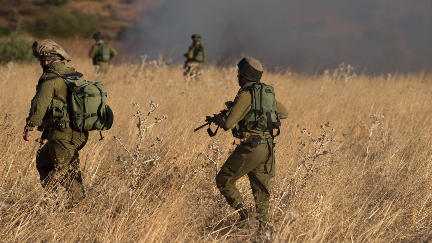 Israeli soldiers on Thursday inspect a field where rockets landed.