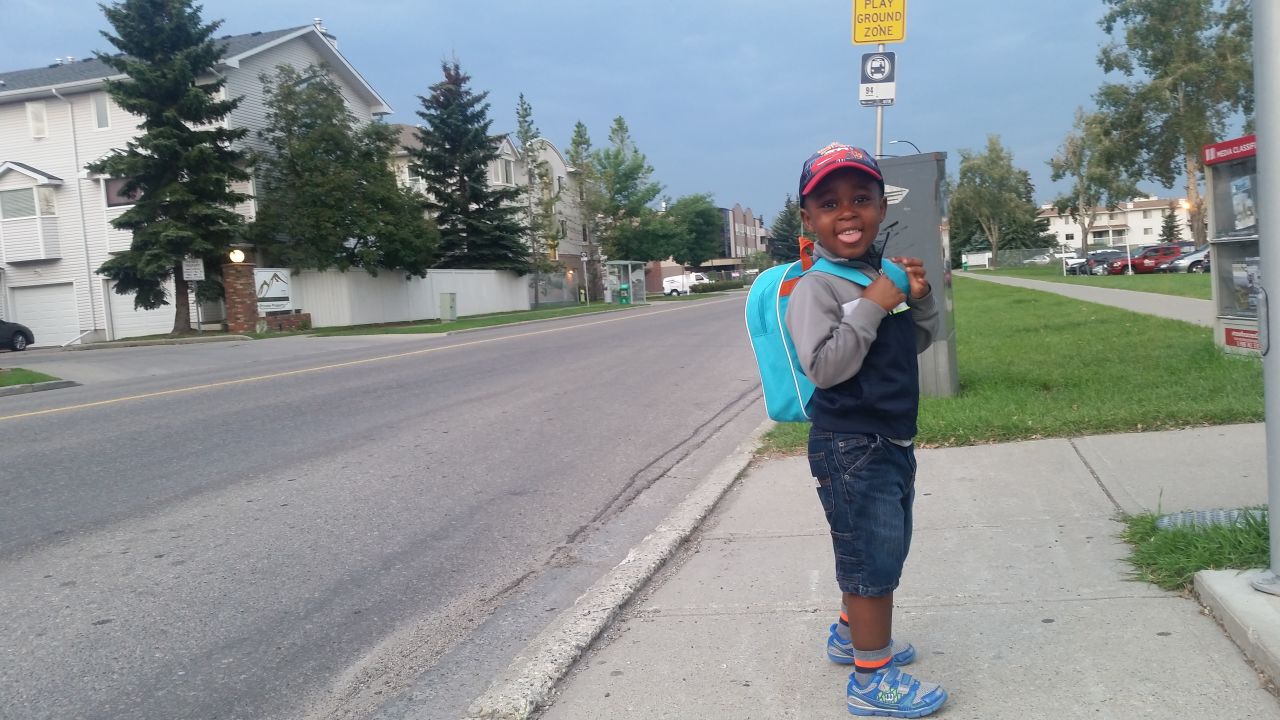 Preston, age 3, waits for the bus in Calgary, Alberta, wearing a backpack that holds his favorite Spider-Man toy, a school diary, banana, packet of apple juice and his snack box.