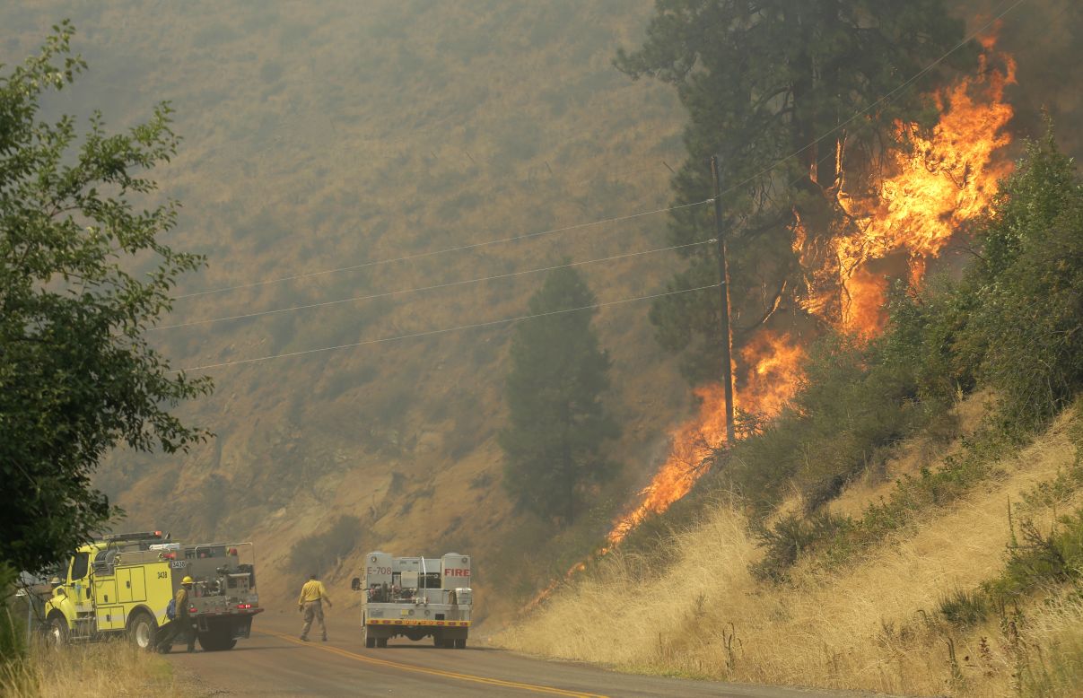 Firefighters battle a wildfire on a hillside in Twisp on August 20.