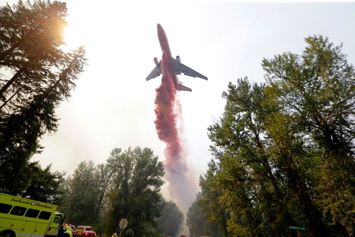 A tanker drops fire retardant on a wildfire that flared up in Twisp on August 20. More than 100 wildfires were roaring throughout the state, according to Gov. Jay Inslee. "I want to say this is an unprecedented cataclysm in our state," Inslee said. "There are 390,000 acres burning. Last year was bad with 250,000 acres." 