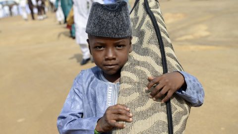 A young Nigerian arrives with his prayer mat to pray at the Isa Kazaure praying ground in Jos on July 17.