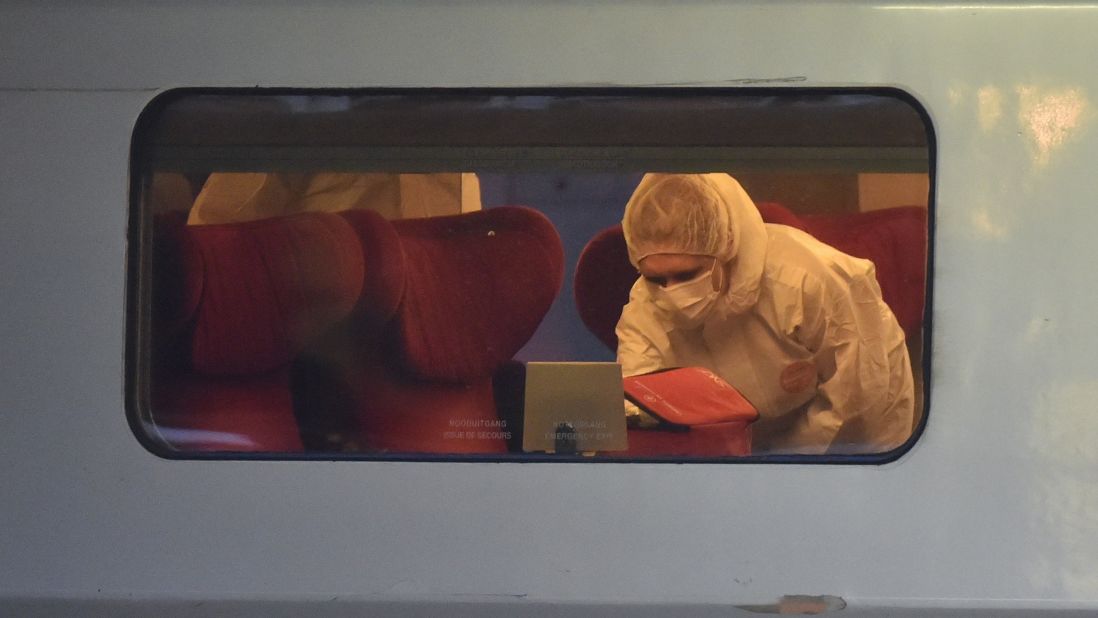 Police inspect the crime scene inside the train.  
