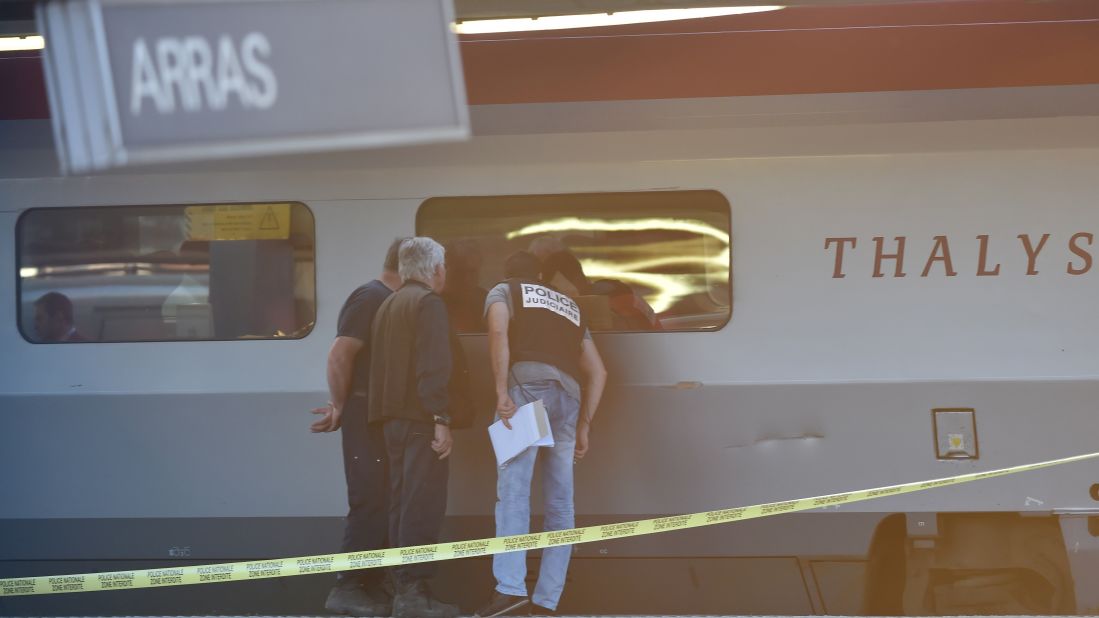 Crime investigators look into the window of the train. 