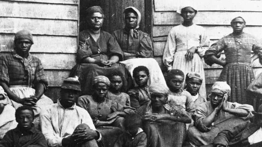 Portrait of Civil War 'contrabands,' fugitive slaves who were emancipated upon reaching the North, sitting outside a house, possible in Freedman's Village in Arlington, Virginia, mid 1860s. Up to 1100 former slaves at a time were housed in the government established Freedman's Village in the thirty years in which it served as a temporary shelter for runaway and liberated slaves. (Photo by Hulton Archive/Getty Images)