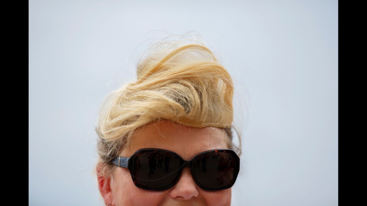 A Trump supporter wears a hairpiece similar to Trump's signature style.