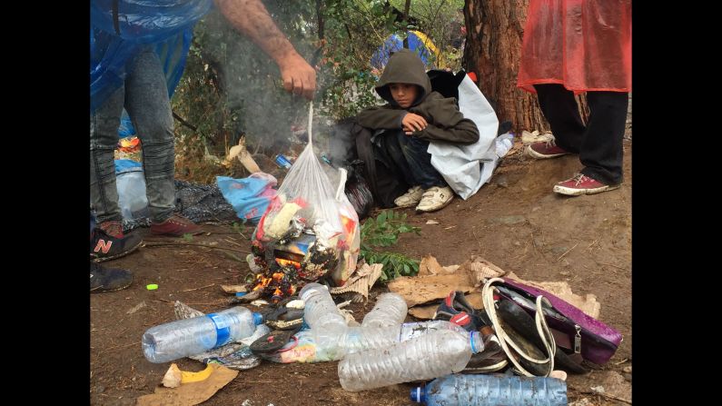A mother burns garbage to keep her and her children warm. 