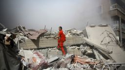A member of the Syrian Red Crescent inspect rubble searching for victims in the rebel-held area of Douma, east of the capital Damascus, following shelling and air raids by Syrian government forces on August 22, 2015. At  least 20 civilians and wounded or trapped 200 in Douma, a monitoring group said, just six days after regime air strikes killed more than 100 people and sparked international condemnation of one of the bloodiest government attacks in Syria's war.   AFP PHOTO / ABD DOUMANY        (Photo credit should read ABD DOUMANY/AFP/Getty Images)
