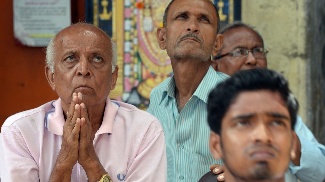Onlookers in Mumbai, India, watch falling share prices on a screen outside the Bombay Stock Exchange on August 24. 