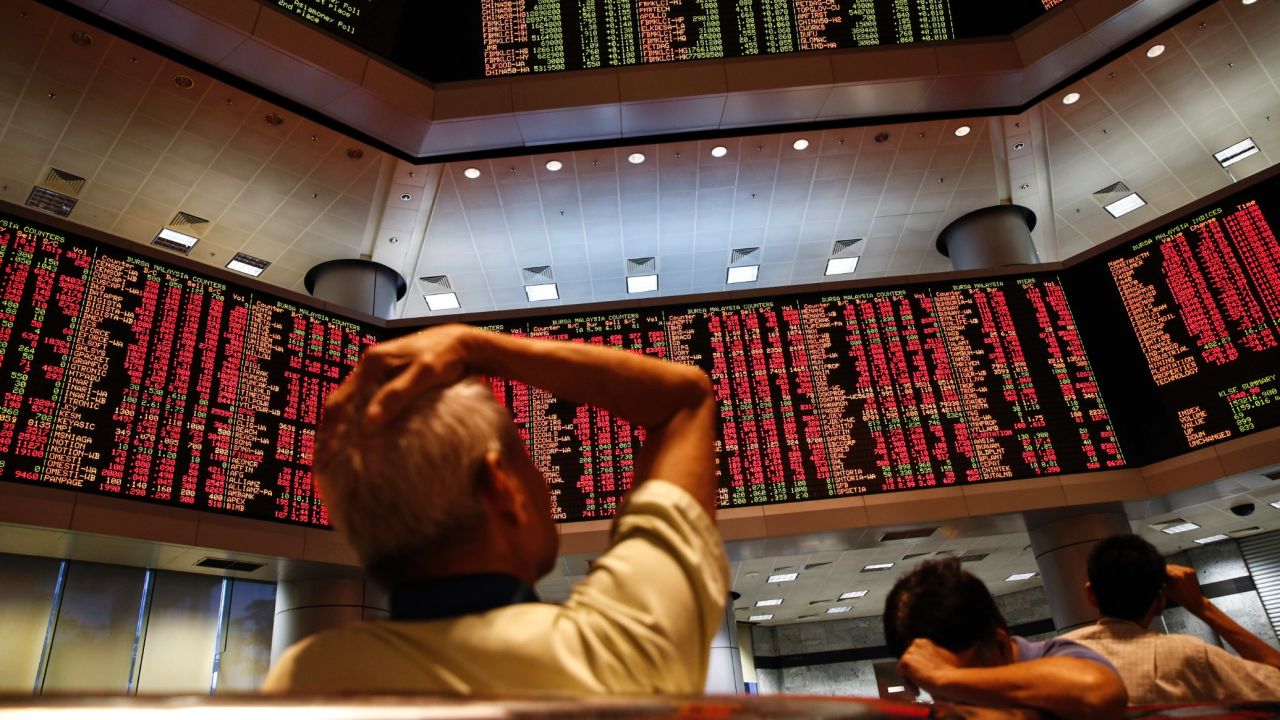 People watch dropping share prices at a private stock market gallery in Kuala Lumpur, Malaysia, on August 24.