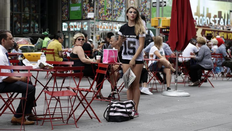 A street performer waits for her handlers before she walks around seminude in Times Square on August 19.