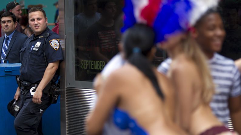 A police officer looks on as women pose for pictures on August 19.