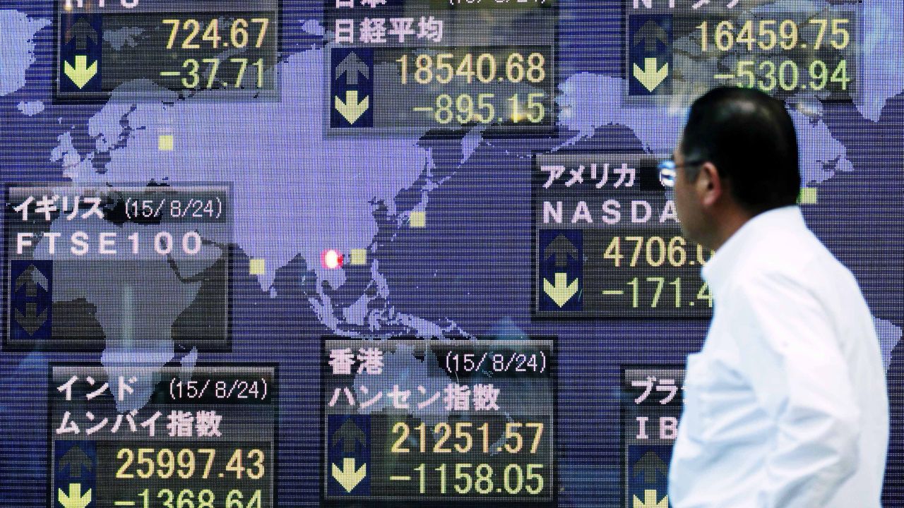 A man looks at the Nikkei Stock Average, which dropped 895.15 points, or 4.61%, at the end of trading on August 24 in Tokyo.