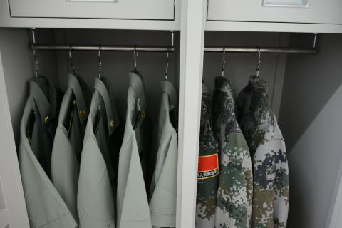 Soldiers' uniforms hang neatly in their dorm room closet on August 22.