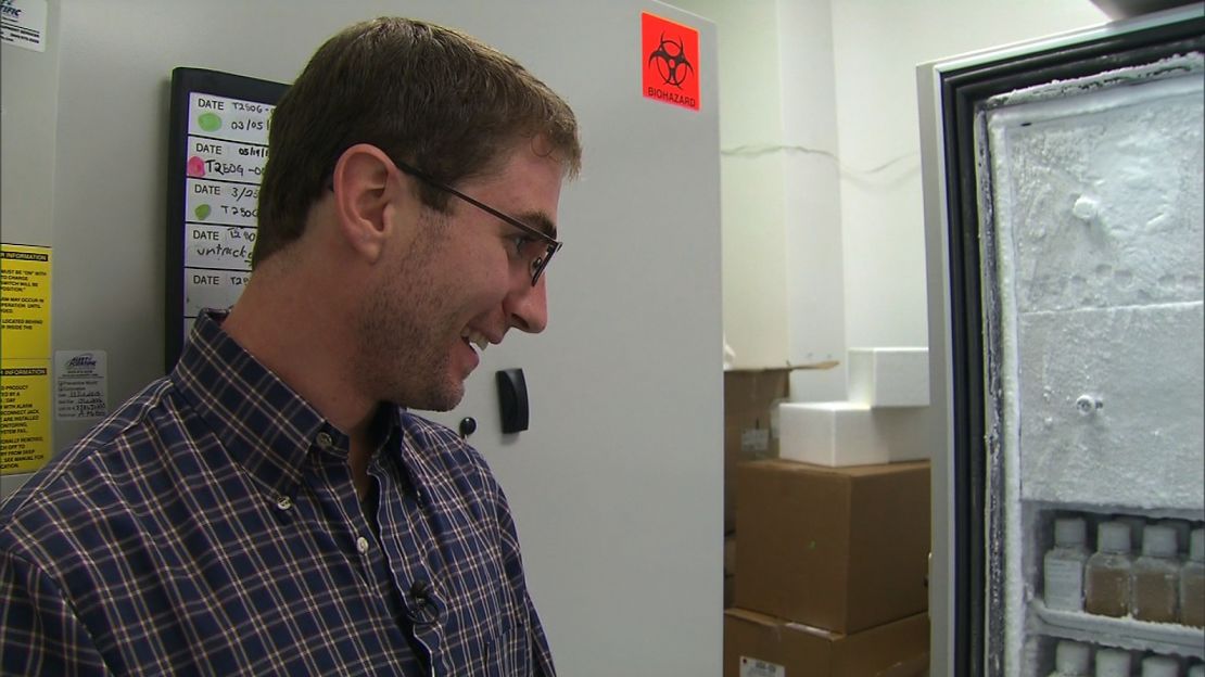 Eric, a poop donor for OpenBiome, looks at bottles of frozen fecal transplants he helped create.