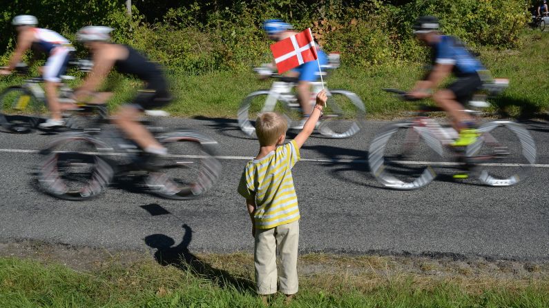 A boy waves the Danish flag as athletes compete in an Ironman race Sunday, August 23, in Copenhagen, Denmark.