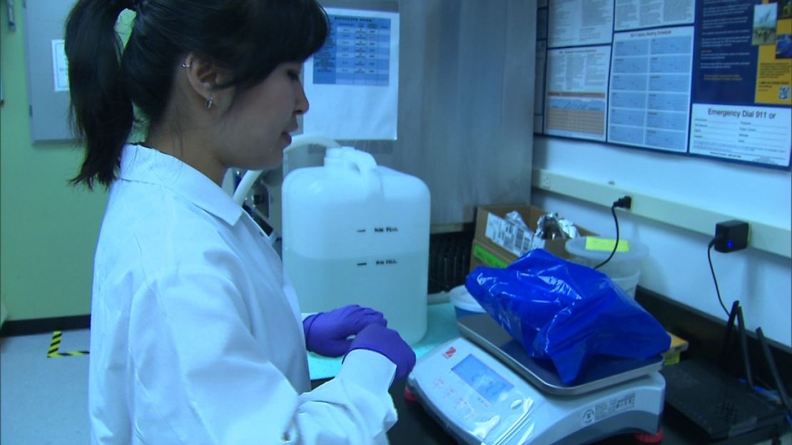 Christina Kim, a lab technician at OpenBiome, weighs Eric's poop donation. 