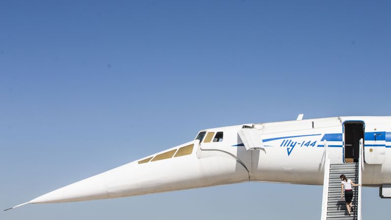 A visitor climbs a ladder to explore a supersonic Tupolev Tu-144 jet at the air show.
